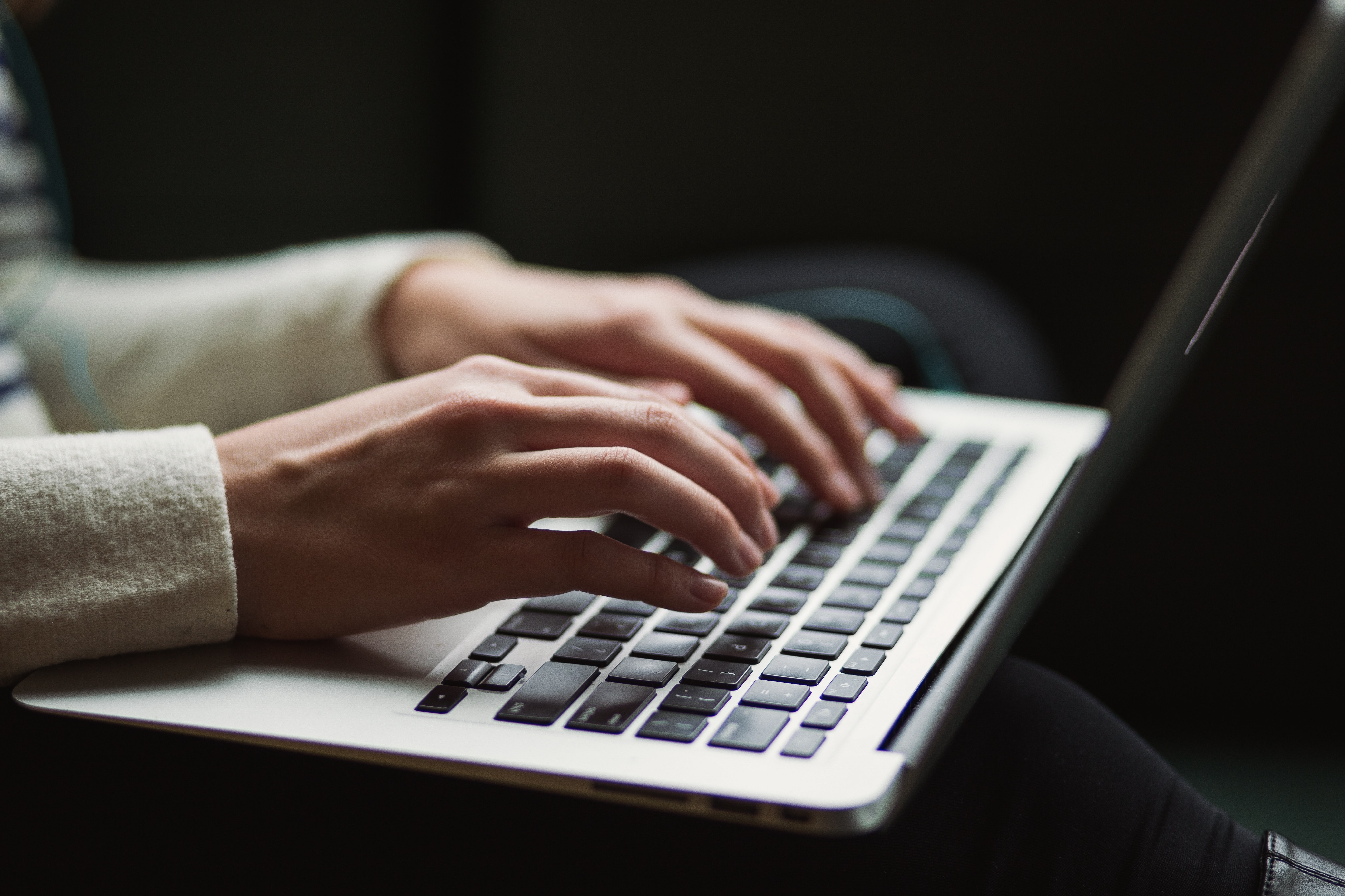 Woman's hands typing on a laptop keyboard