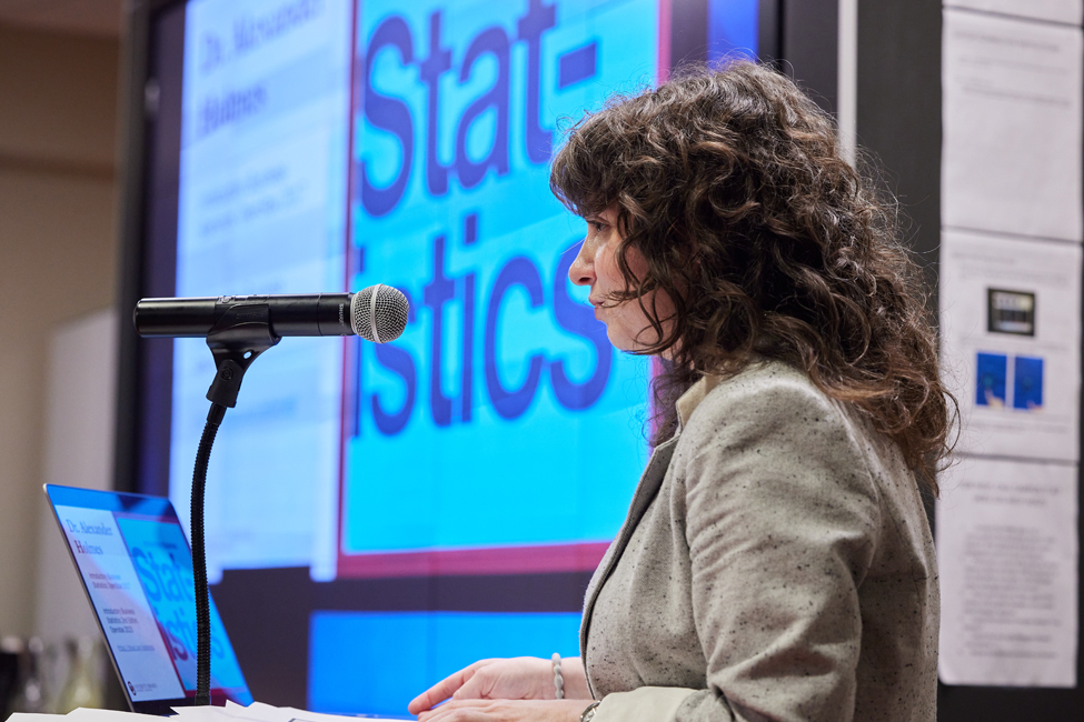 Morgan Briles speaks into a microphone at a podium during her presentation.