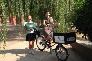 Two women and a bike with a delivery box on the front